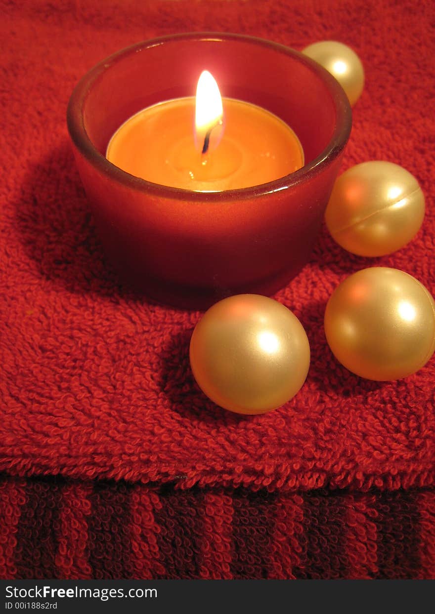 Red candle and bath balls on red towel. Red candle and bath balls on red towel