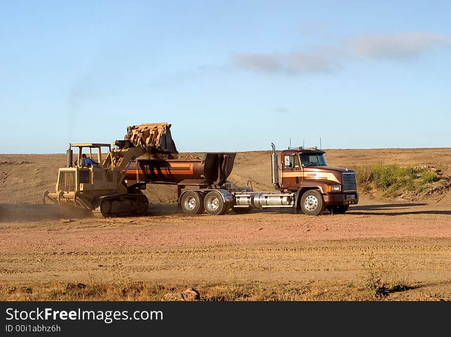 A scoop loader and a truck working at groundworks