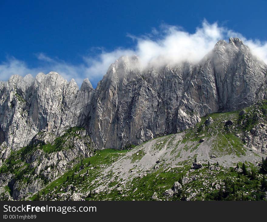 Gastlosen mountain range is part of the Pre-Alps Mountains in the Fribourg canton of Switzerland. The image is focusing on the Sattelspitzen segment, with the highest peak named Ruedigenspitze (2124m), surprising it with the head-in-the-clouds. Gastlosen is the paradise of the best rock-climbers in the area, offering extremely dangerous and natural courses. Gastlosen mountain range is part of the Pre-Alps Mountains in the Fribourg canton of Switzerland. The image is focusing on the Sattelspitzen segment, with the highest peak named Ruedigenspitze (2124m), surprising it with the head-in-the-clouds. Gastlosen is the paradise of the best rock-climbers in the area, offering extremely dangerous and natural courses.