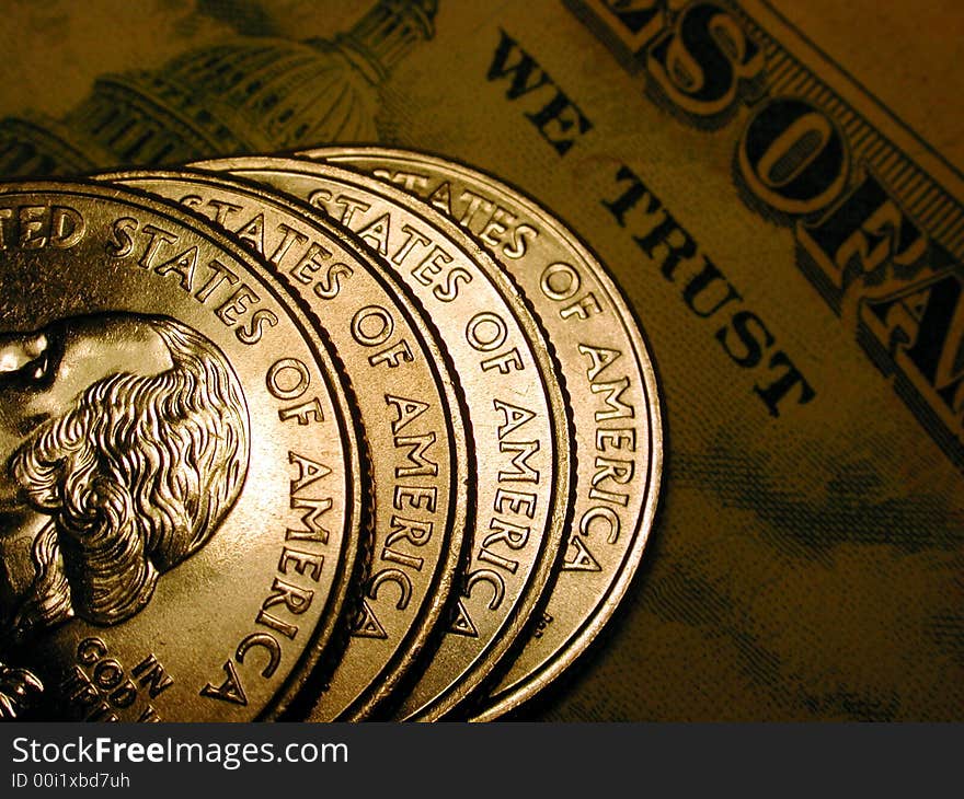 Closeup of uncirculated US coins with a dark bill as the backdrop. Closeup of uncirculated US coins with a dark bill as the backdrop.