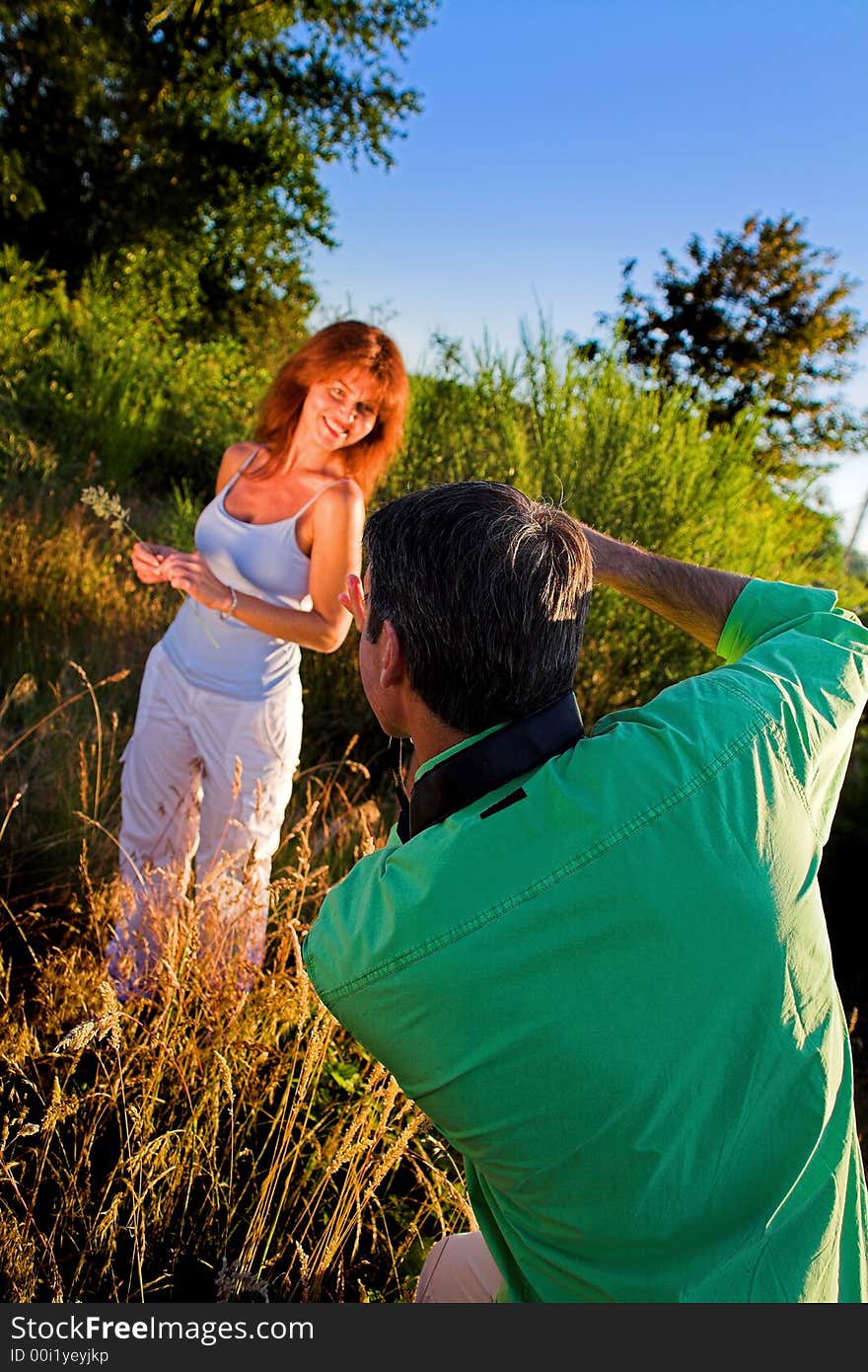 Couple playing outside on a field taking pictures