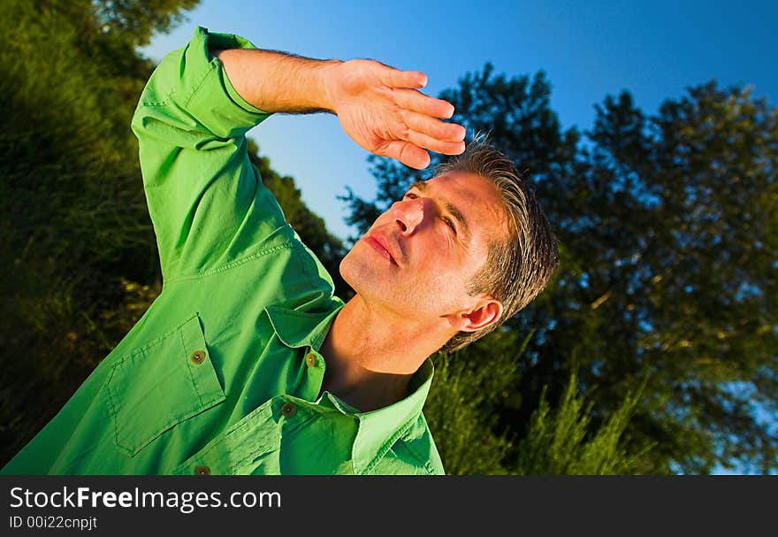 Man portrait outdoor on a field over blue sky