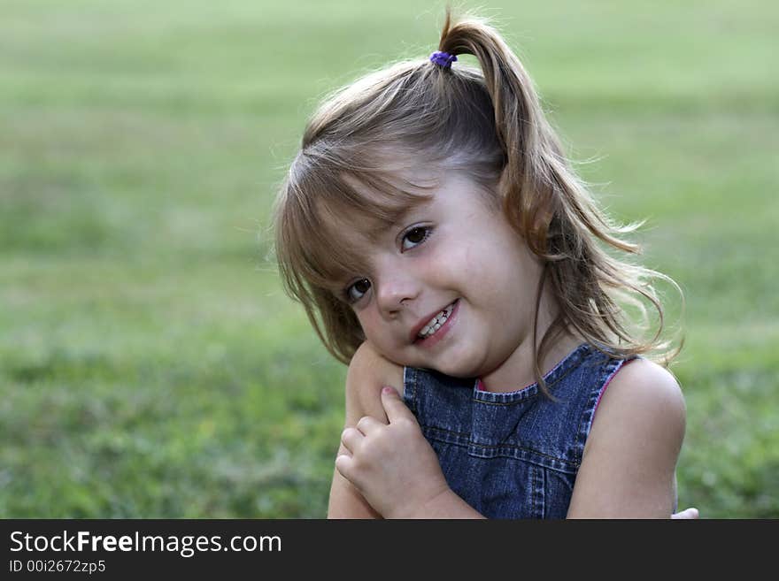 Young girl with big smile in grass. Young girl with big smile in grass