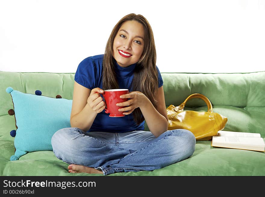 Pretty asian hispanic lady sitting on asofa enjoying her morning coffe on white background. Pretty asian hispanic lady sitting on asofa enjoying her morning coffe on white background