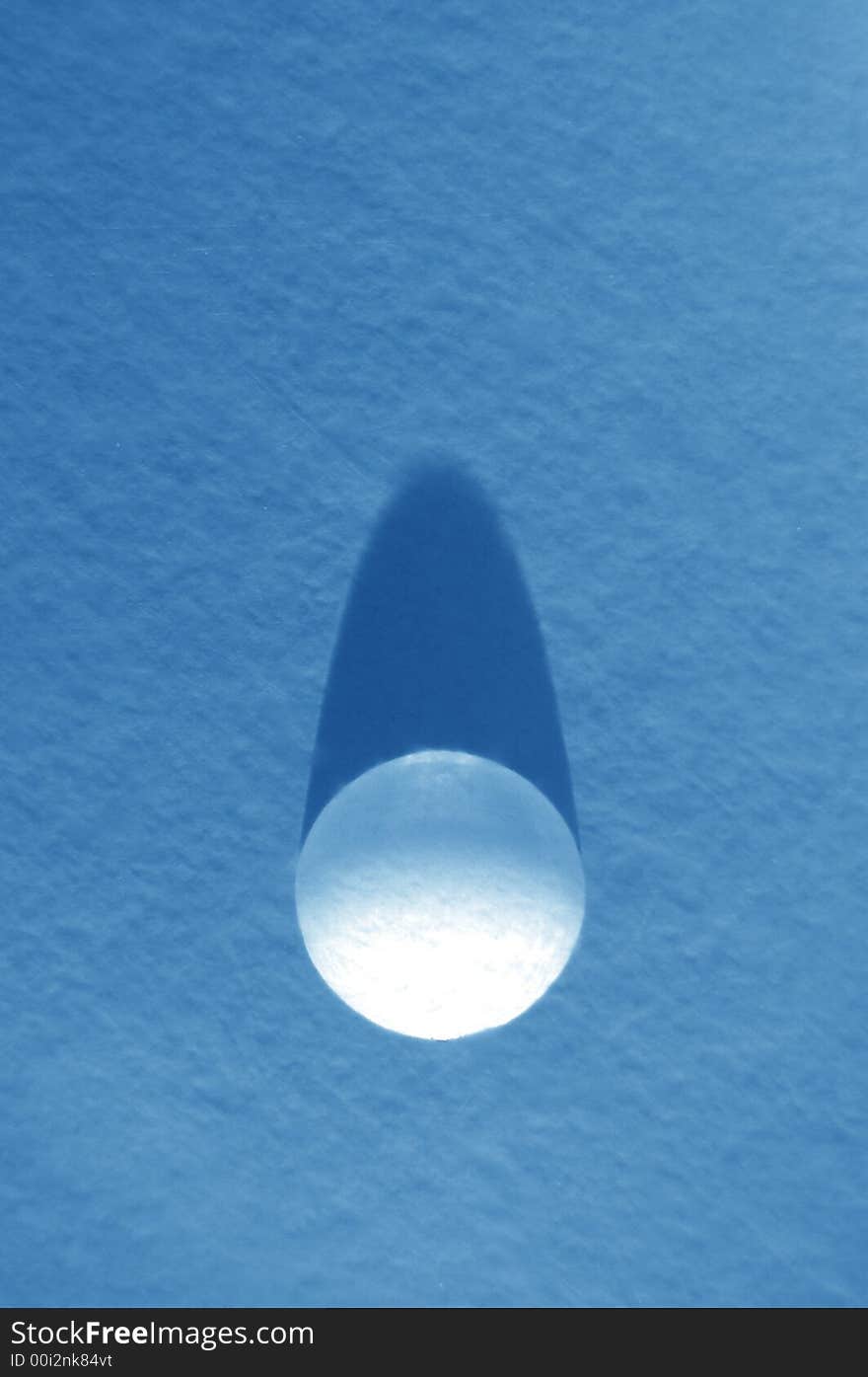 Water drop on a blue background refracting a sunlight