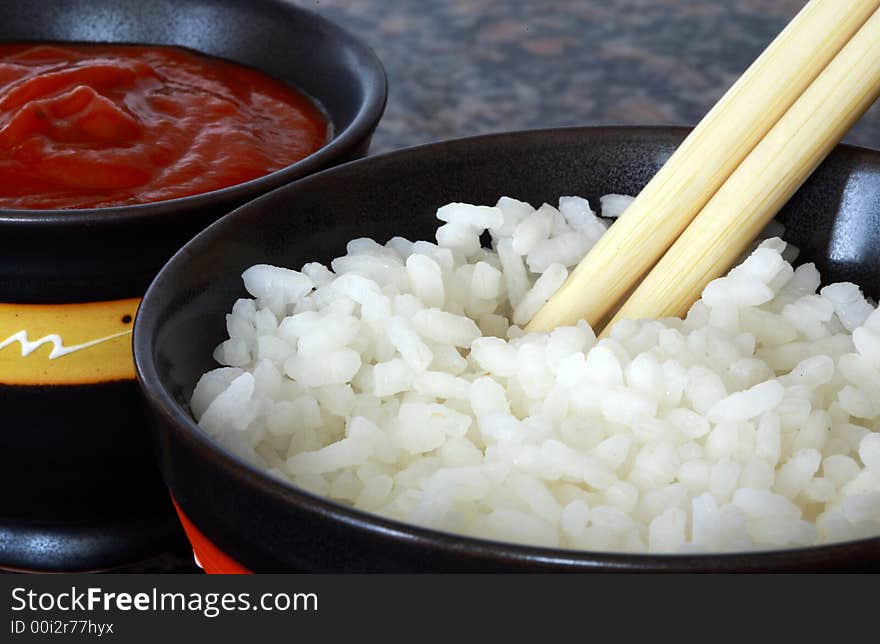 Chinesse rice and hot spice sauce bowl with two chopsticks. Chinesse rice and hot spice sauce bowl with two chopsticks