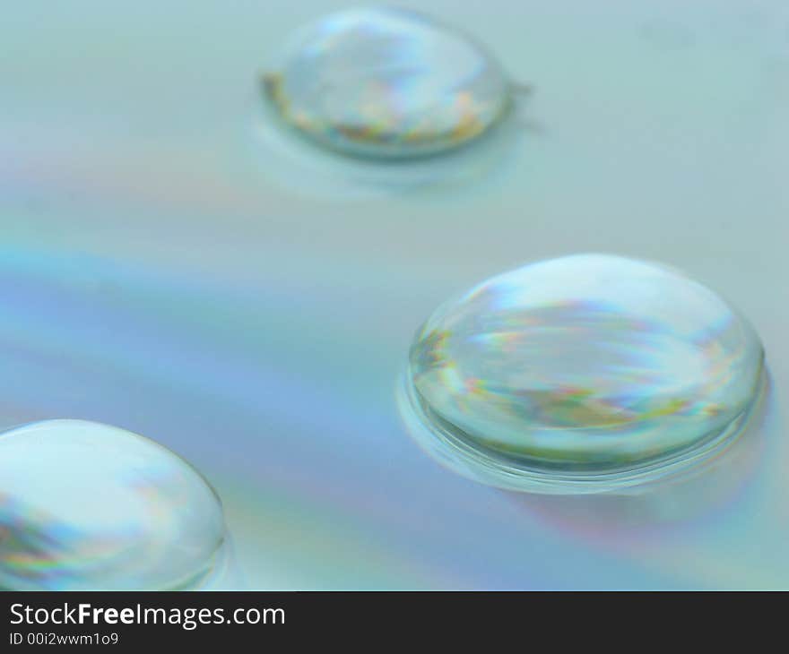 Water drops on a CD surface displaying all the colors of the rainbow. Water drops on a CD surface displaying all the colors of the rainbow