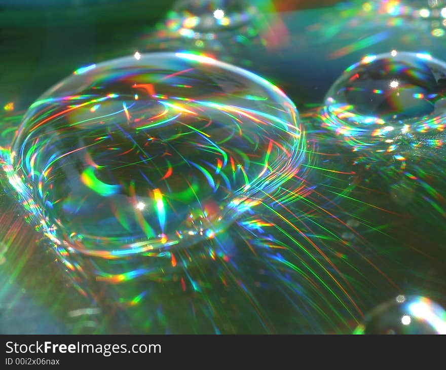 Water drops on a CD surface displaying all the colors of the rainbow. Water drops on a CD surface displaying all the colors of the rainbow