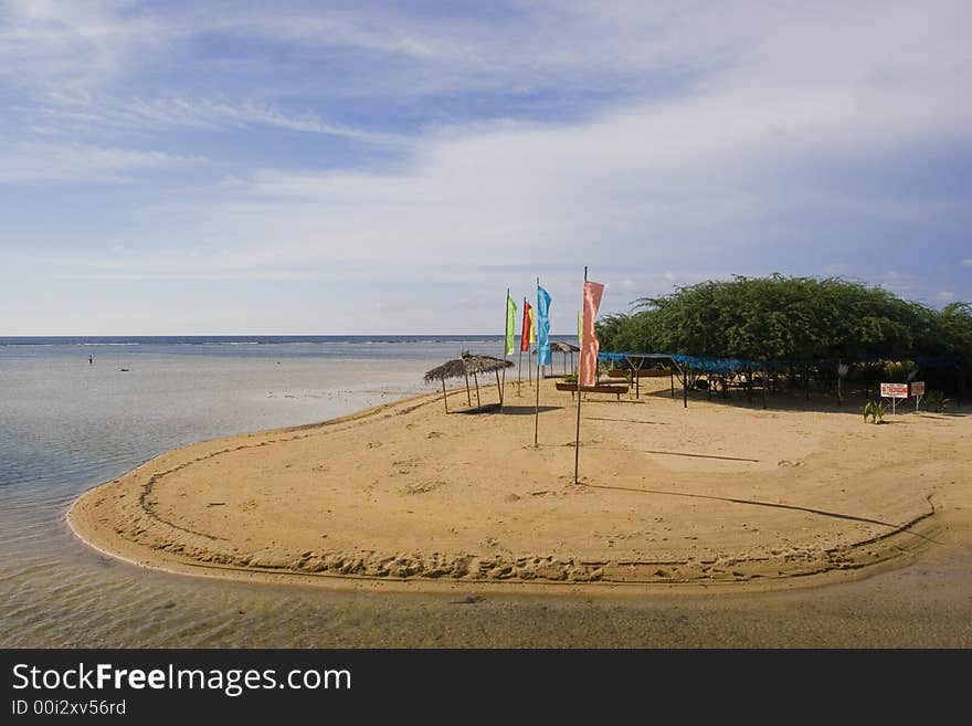 Flags lined up with a hut by the seashore. Flags lined up with a hut by the seashore