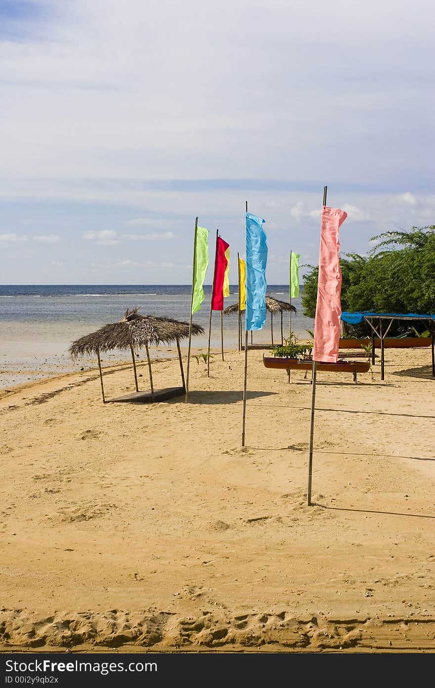 A few flags and a beach hut on the shore. A few flags and a beach hut on the shore