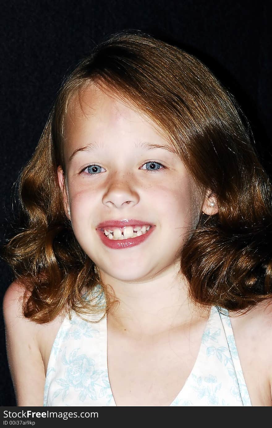 Pretty little young blue eyed girl with reddish brown hair and a big smile posing for a photo. Pretty little young blue eyed girl with reddish brown hair and a big smile posing for a photo.