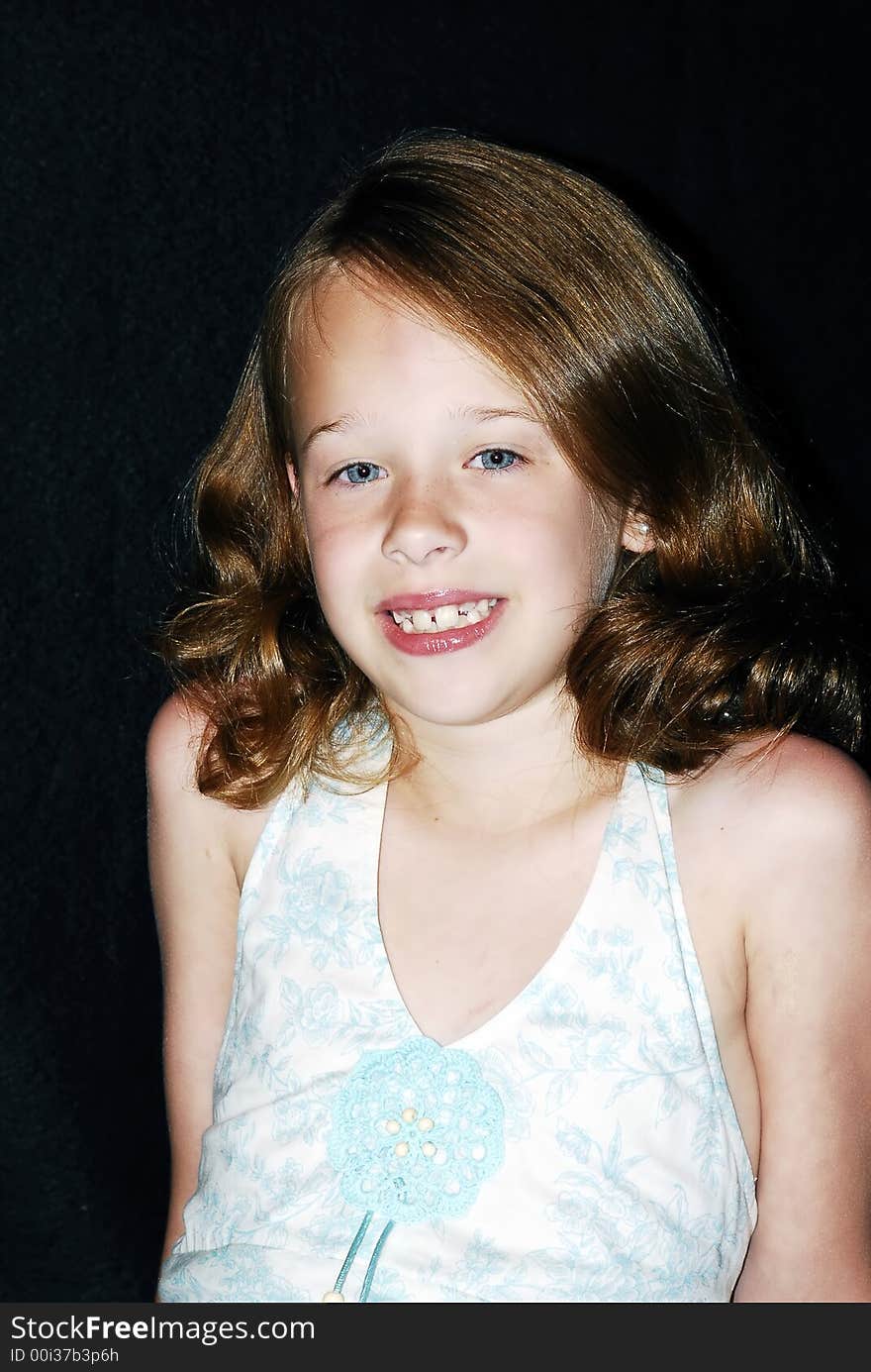 Pretty little young blue eyed girl with reddish brown hair and a big smile posing for a photo. Pretty little young blue eyed girl with reddish brown hair and a big smile posing for a photo.