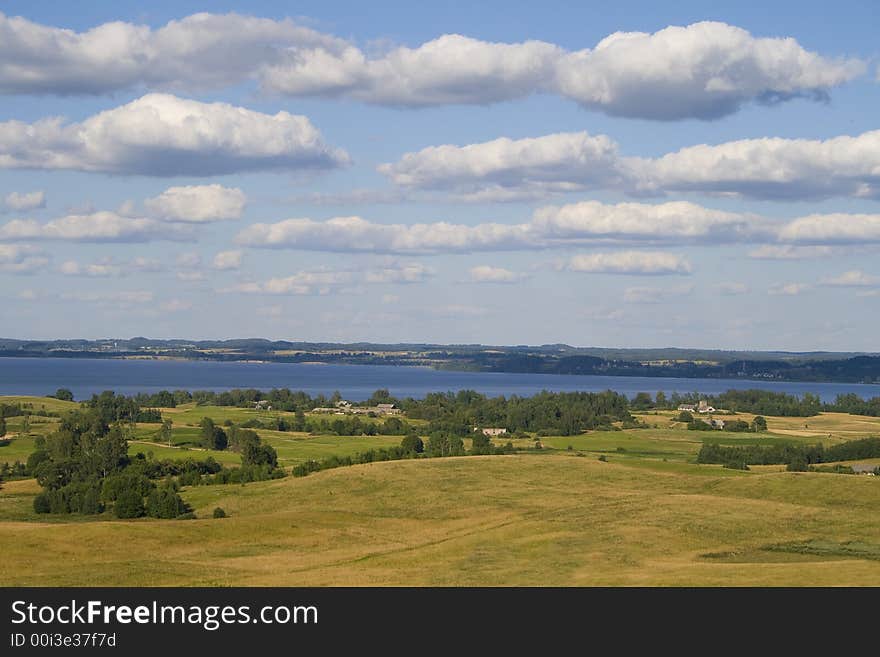 Landscape of fields and lake with clouds, captured in Latvia. Landscape of fields and lake with clouds, captured in Latvia