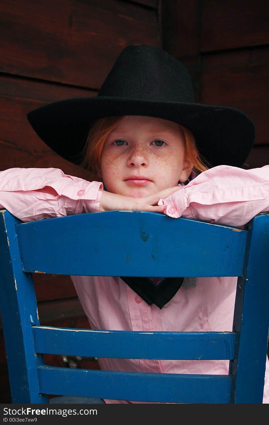 Little cowgirl sitting on a chair