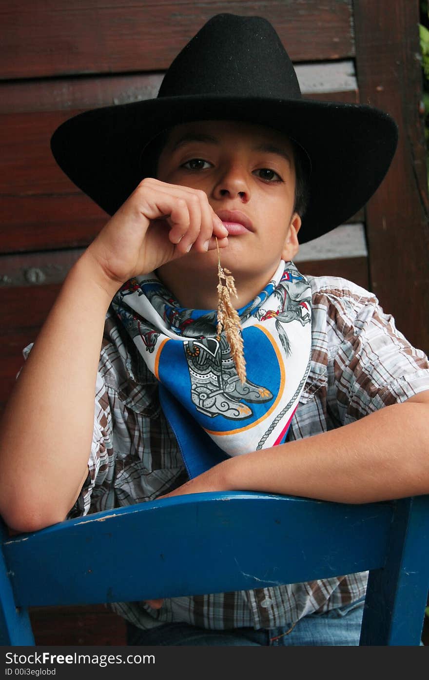 Little cowboy with grass in the mouth