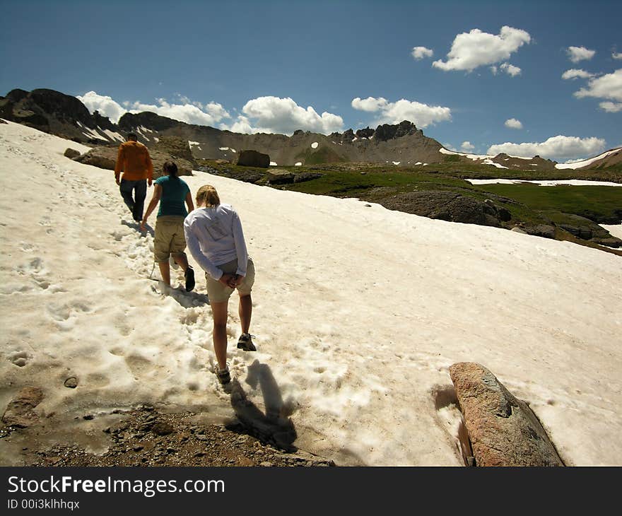 Hikers trek through the snow during the summertime near Silverton, Colorado. Hikers trek through the snow during the summertime near Silverton, Colorado.