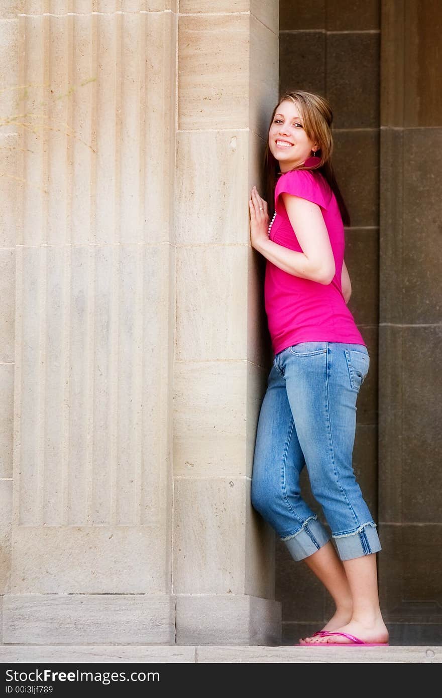 Full-body portrait of a smiling teen pushing agaisnt the pillar of a school building. Full-body portrait of a smiling teen pushing agaisnt the pillar of a school building.