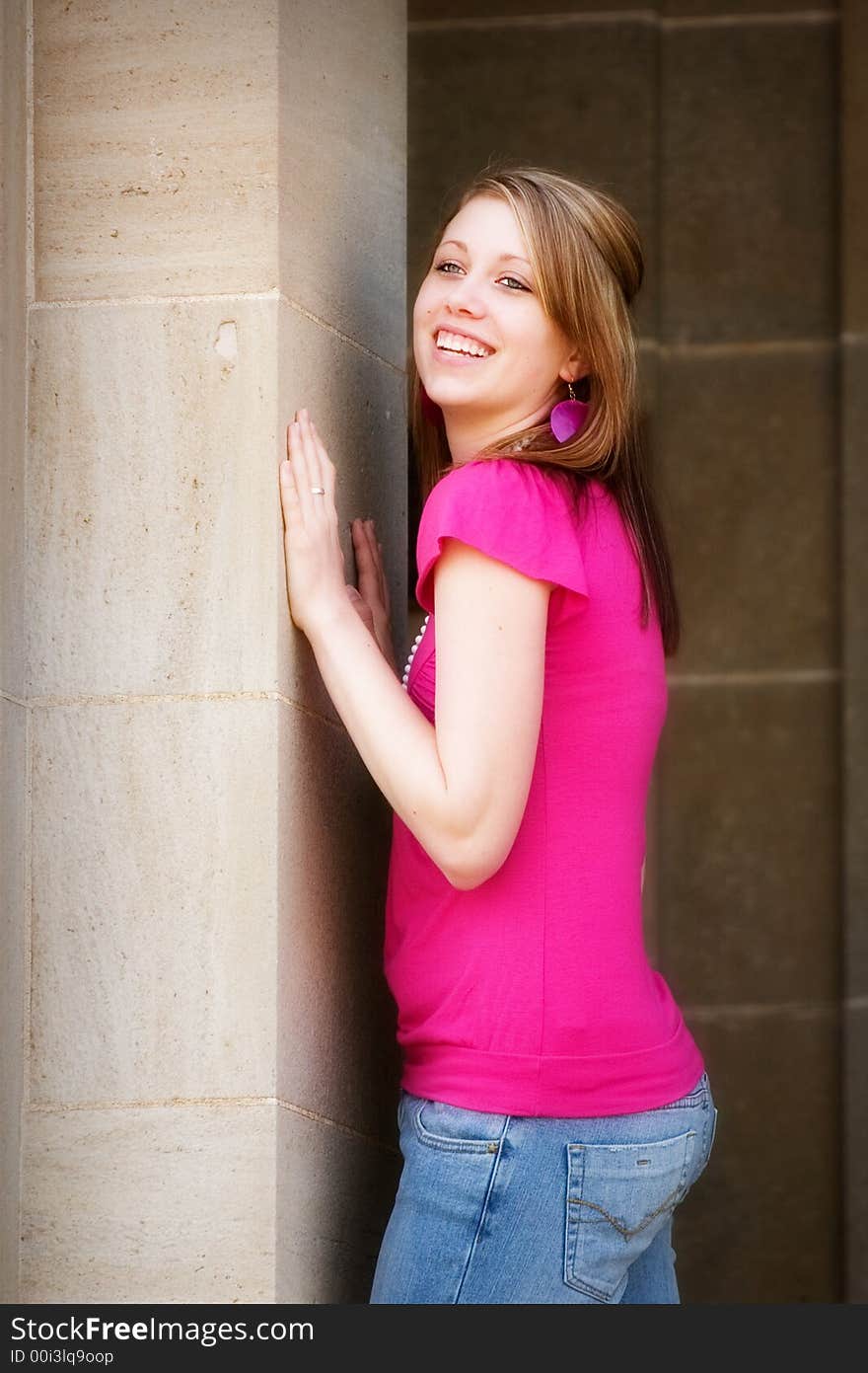 Portrait of a smiling teen pushing agaisnt the pillar of a school building. Portrait of a smiling teen pushing agaisnt the pillar of a school building.