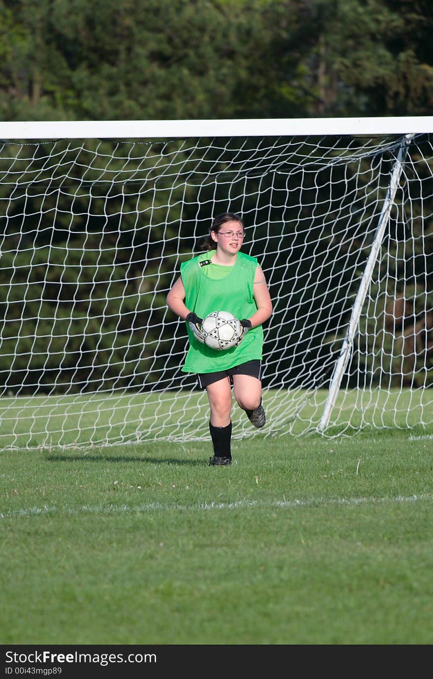 Girl soccer goalie getting ready to kick ball onto field. Girl soccer goalie getting ready to kick ball onto field.