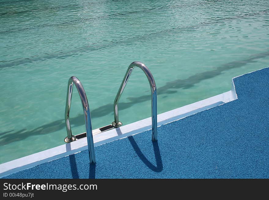 Metal chromeplated ladder in open pool. Metal chromeplated ladder in open pool