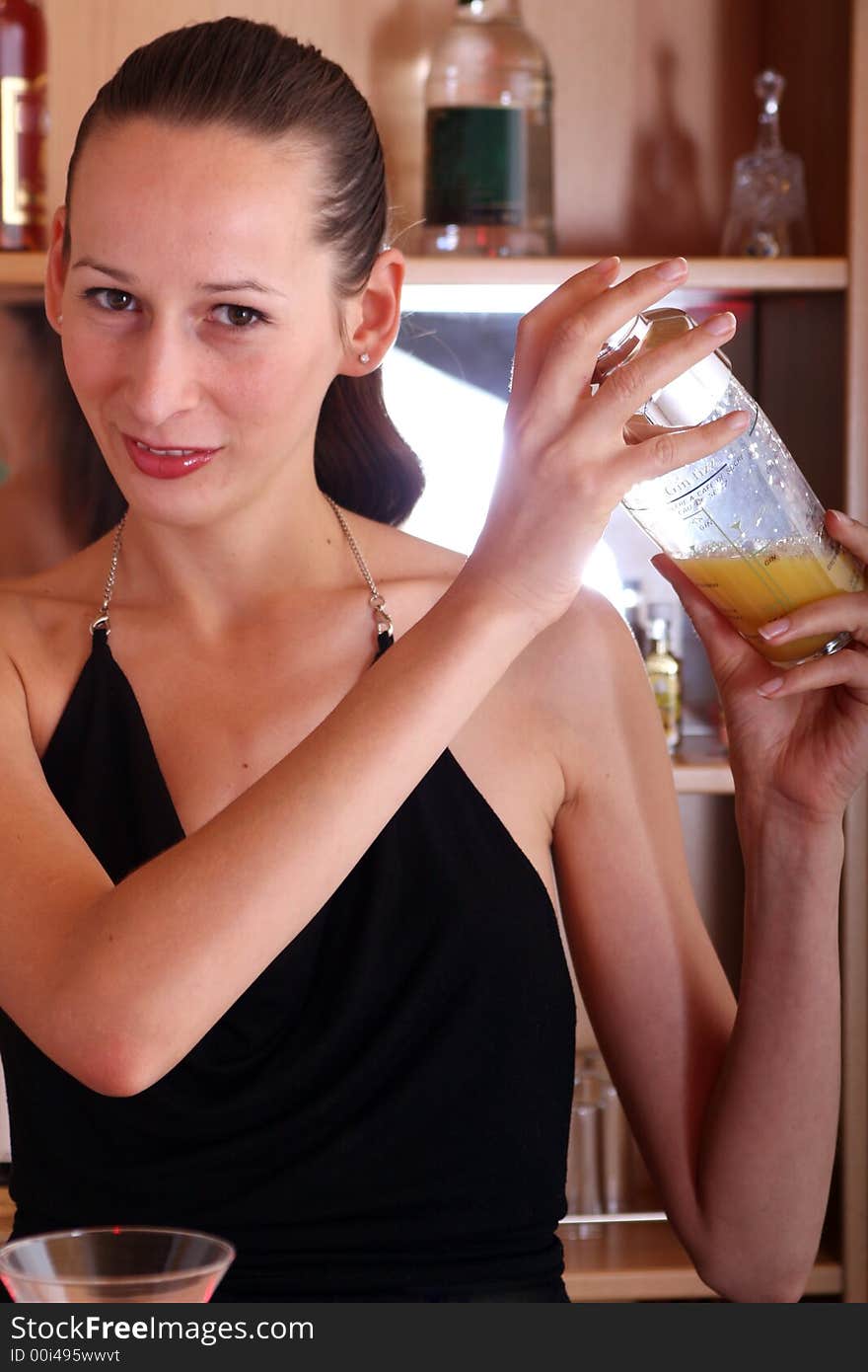 happy woman mixing cocktail in the bar