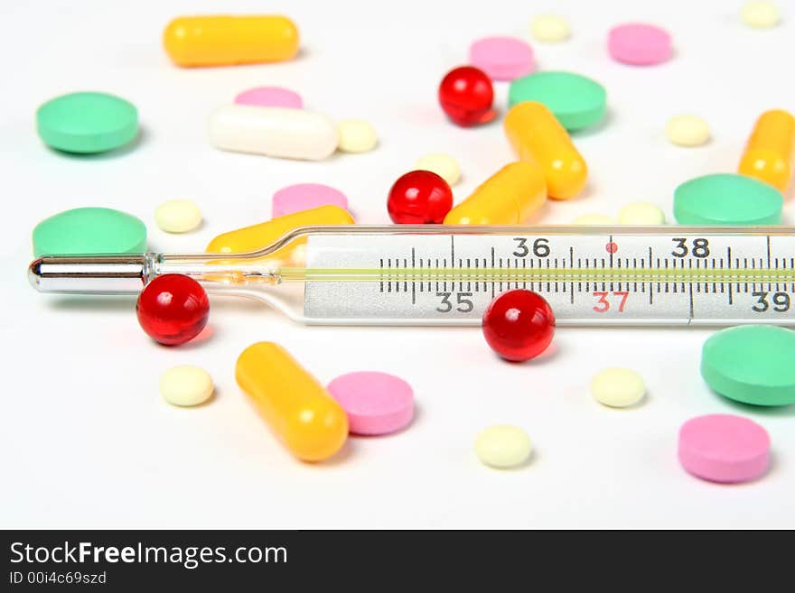 thermometer and pills on white background