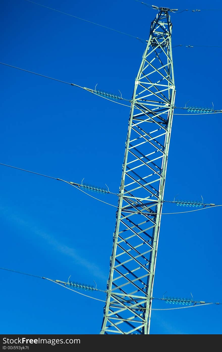 Power lines tower against a blue sky