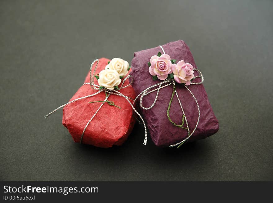 Gift wrapped in purple and pink with decorative flowers and silver ribbon. Gift wrapped in purple and pink with decorative flowers and silver ribbon