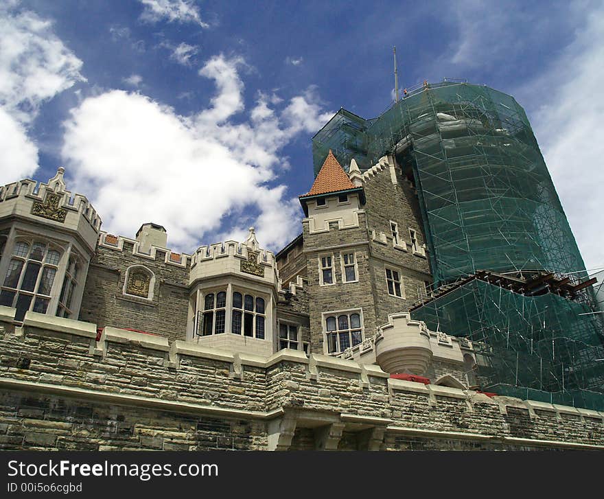 A grand castle is partly covered by scaffold and net while under repair. A grand castle is partly covered by scaffold and net while under repair.