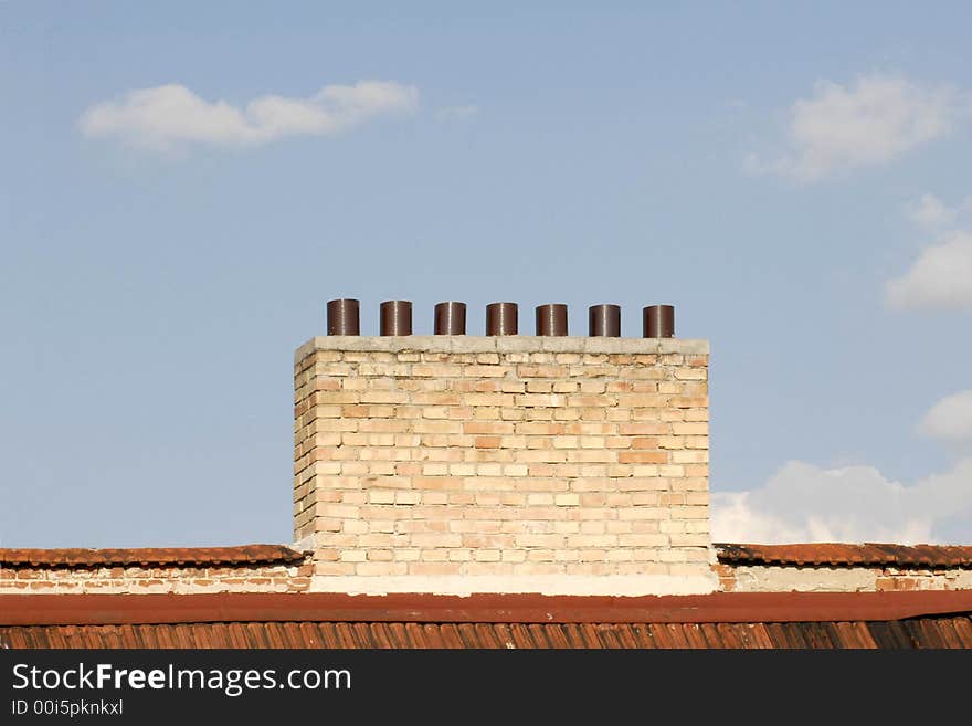 Chimney On Red Roof In Front Of Clear Blue Sky