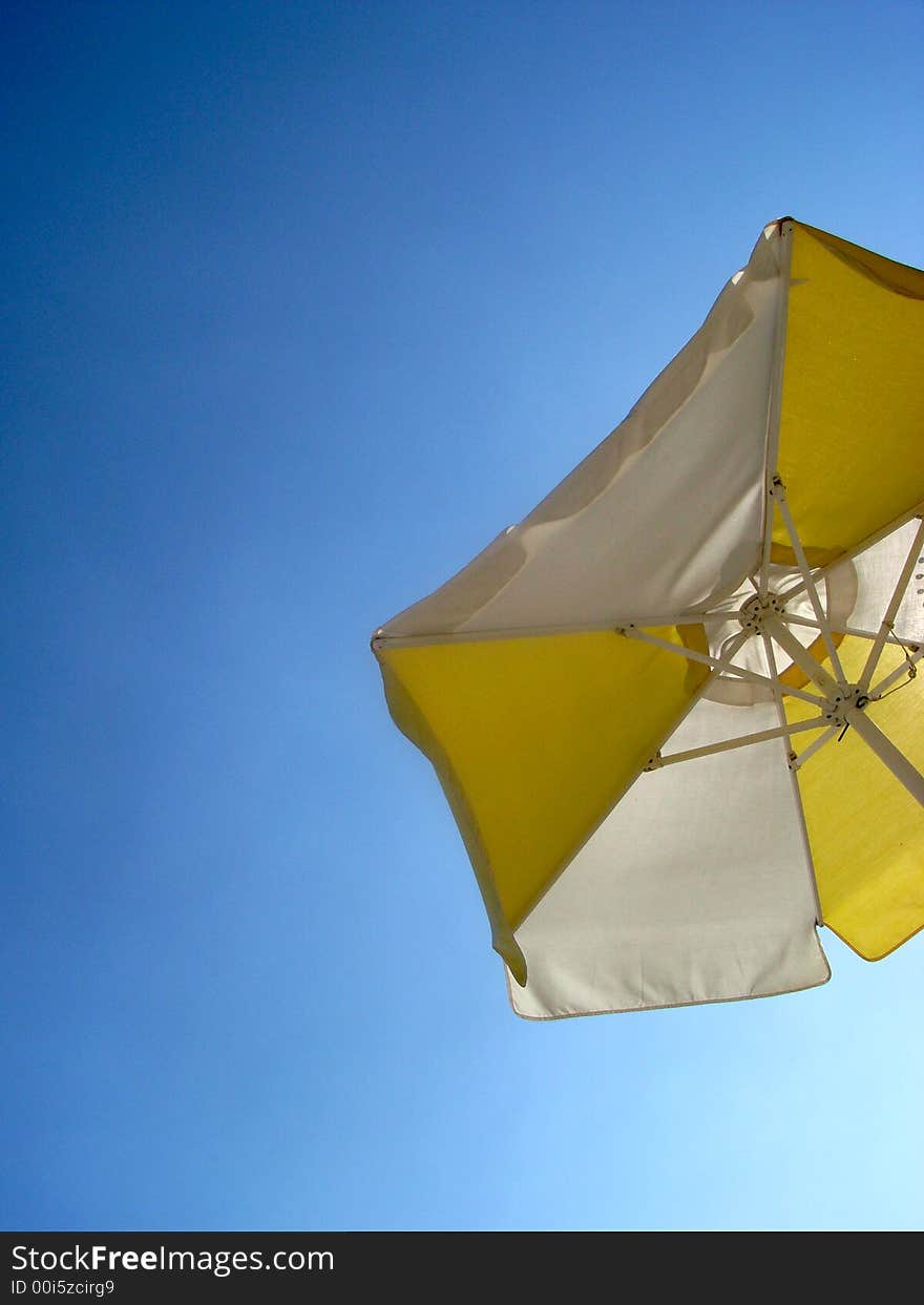 A white sunshade against a deep blue sky.