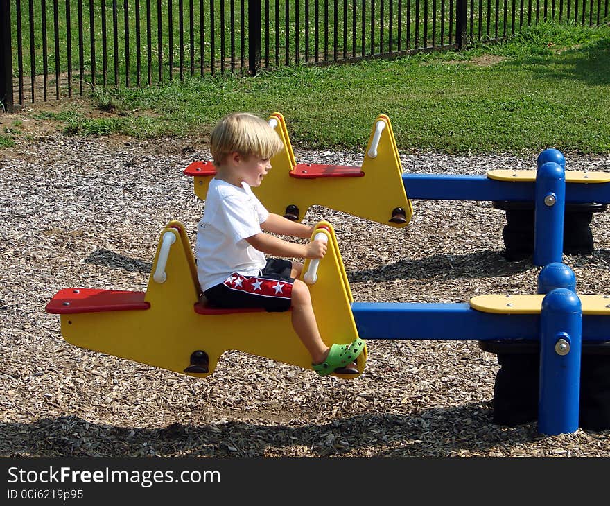 Young boy playing on a seesaw. Young boy playing on a seesaw