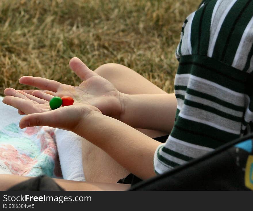 The hands of a youth as he examines the colors his candy has left on his hands. The hands of a youth as he examines the colors his candy has left on his hands.