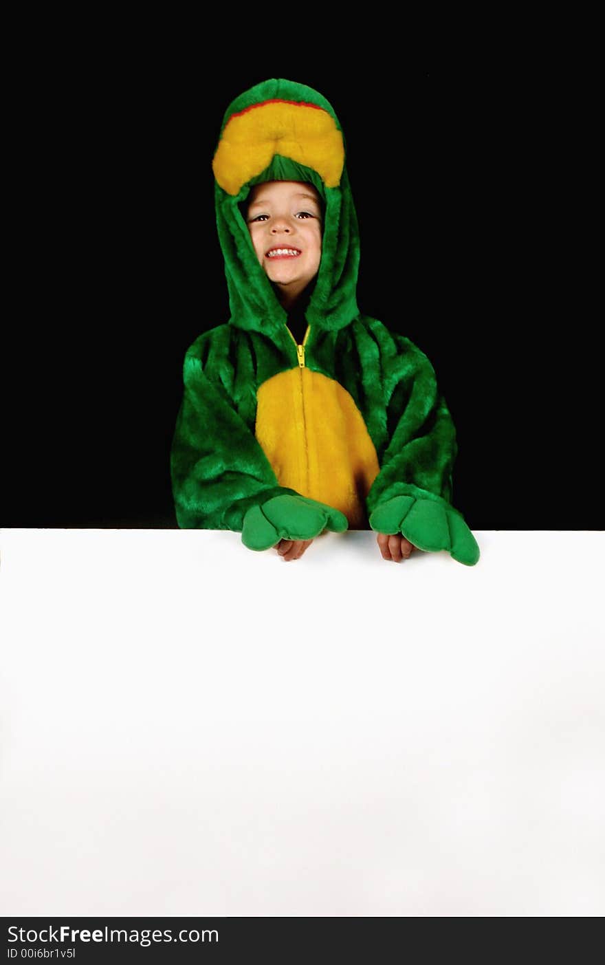 A little girl dressed up in a frog costume holds a blank sign for any message. A little girl dressed up in a frog costume holds a blank sign for any message.