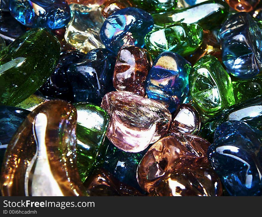 A bin of glass heart, star and moon shapes in various colors.  Focus is on a pink glass heart in the center. A bin of glass heart, star and moon shapes in various colors.  Focus is on a pink glass heart in the center