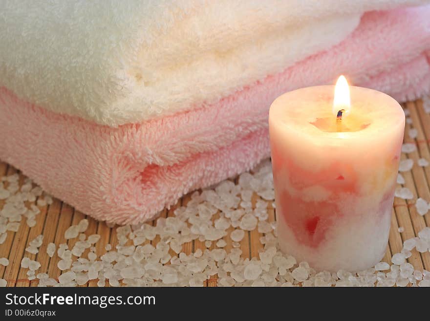 Rosa candle,towels and sea salt on a bamboo mat