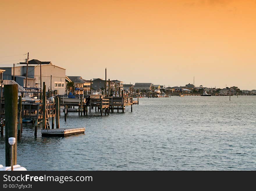 Buildings and boat docks on the sound side of an island gleaming in the glow of the evening sun. Buildings and boat docks on the sound side of an island gleaming in the glow of the evening sun