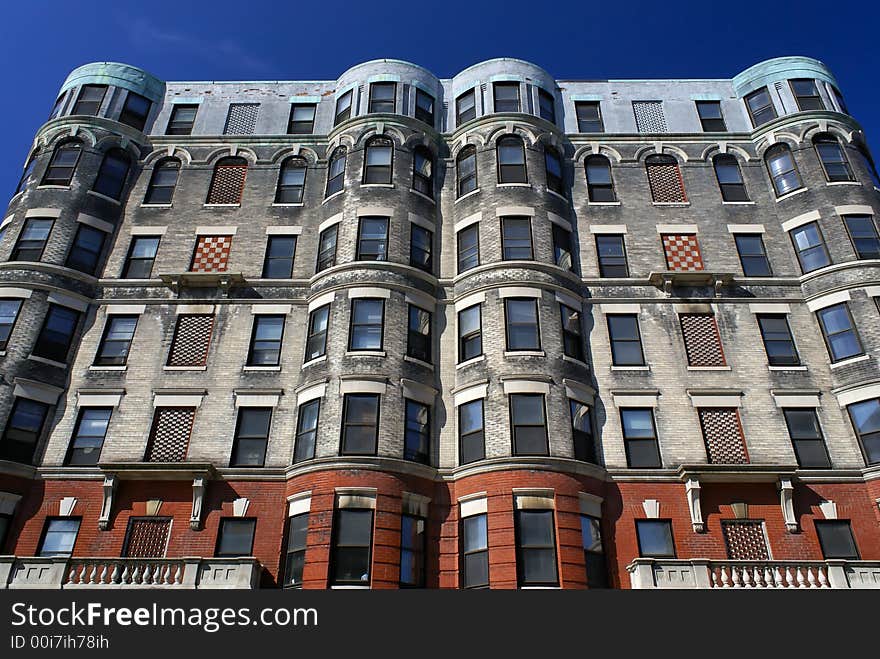 Subtle yet ornate apartment house in downtown cambridge massachusetts with checker board designs and round corners against a deep blue sky. Subtle yet ornate apartment house in downtown cambridge massachusetts with checker board designs and round corners against a deep blue sky