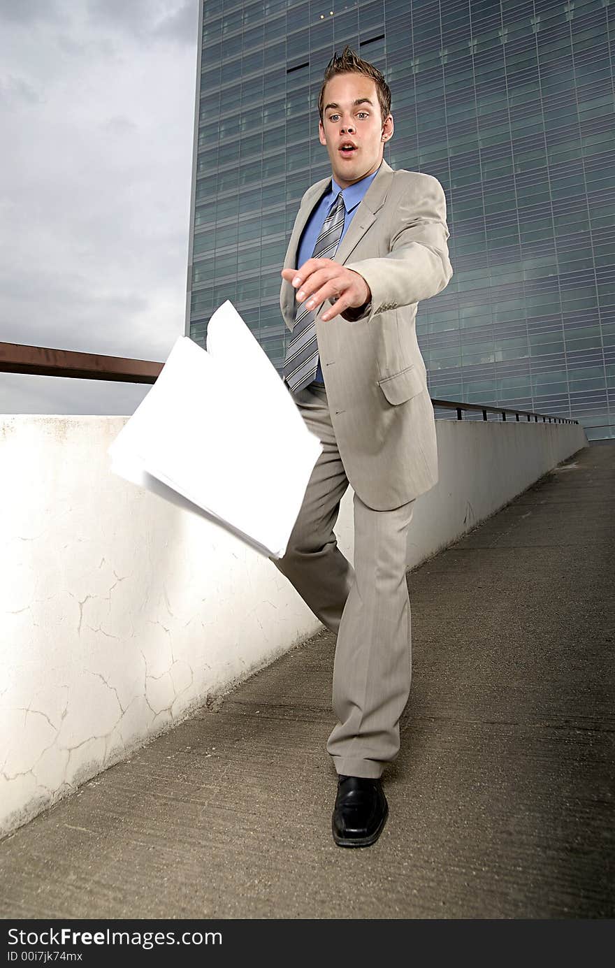 Bad day - fumbler businessman with mobile phone in front of modern business building. Bad day - fumbler businessman with mobile phone in front of modern business building.