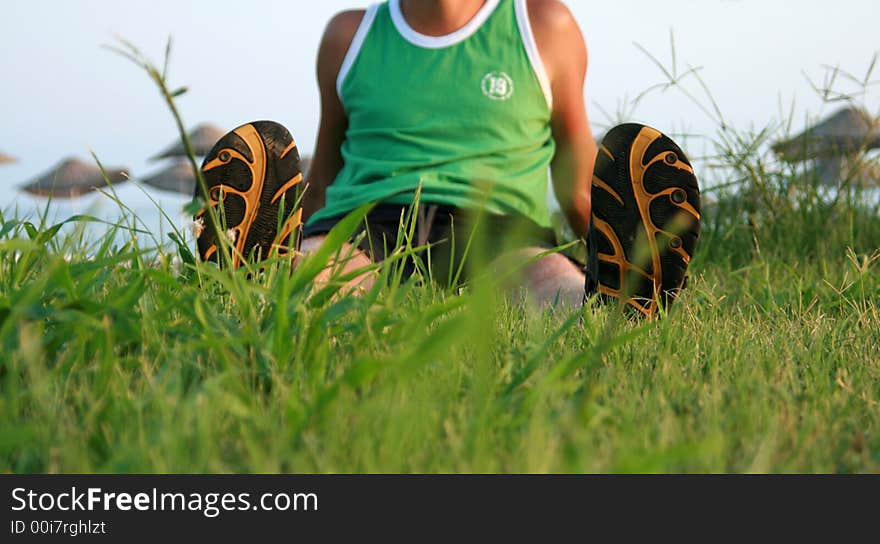 Man sits on grass in summer flip-flops