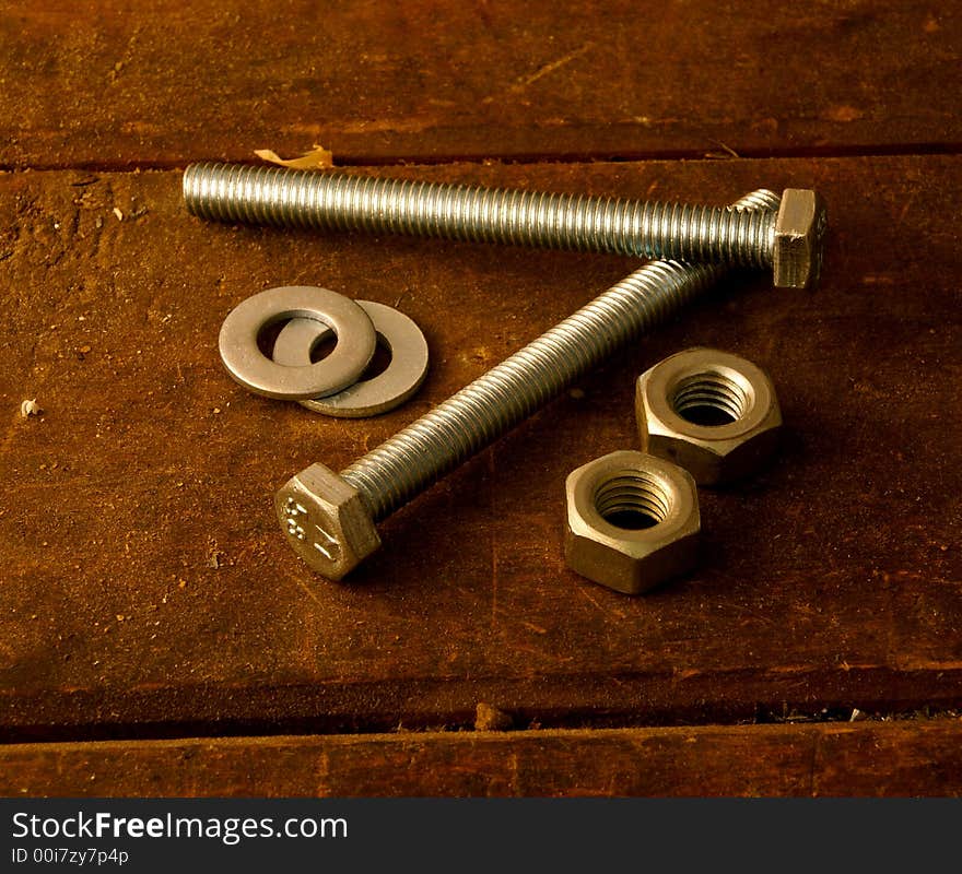 Screws, female screws and washers on work table. Screws, female screws and washers on work table.