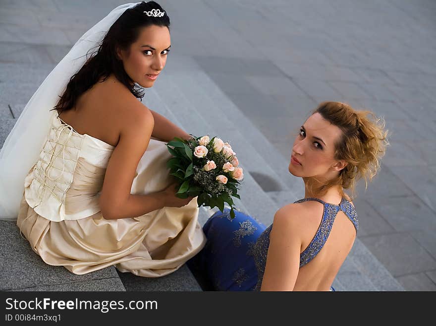 Bride and bridesmaid are talking in front of the church. Bride and bridesmaid are talking in front of the church