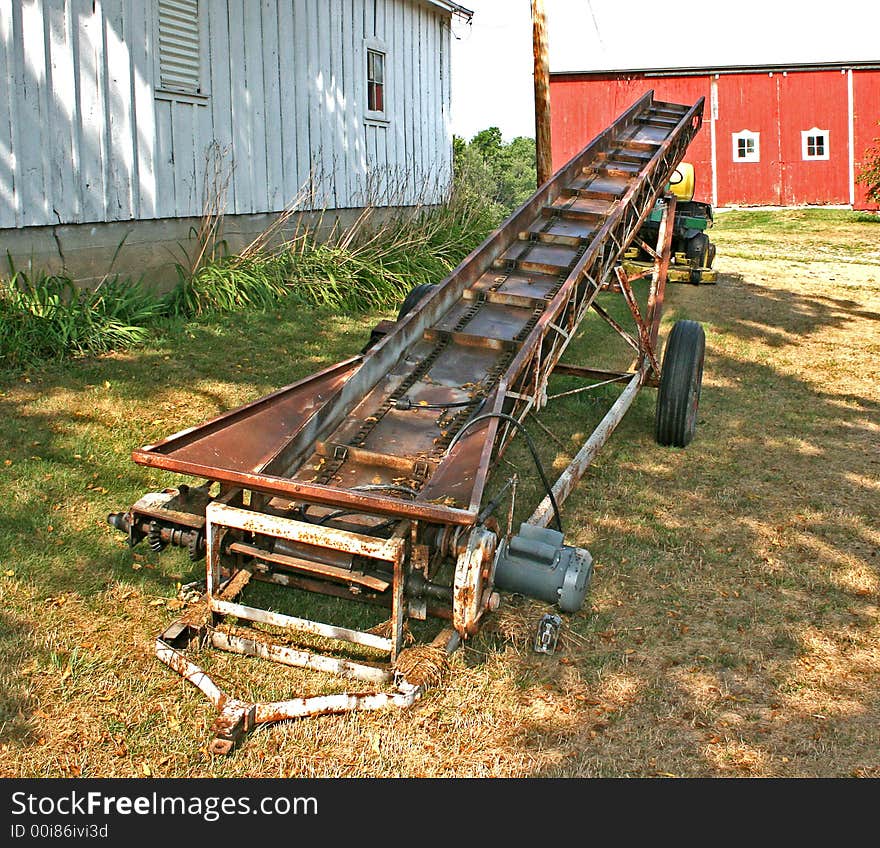 An old, rusty farm loader for hay