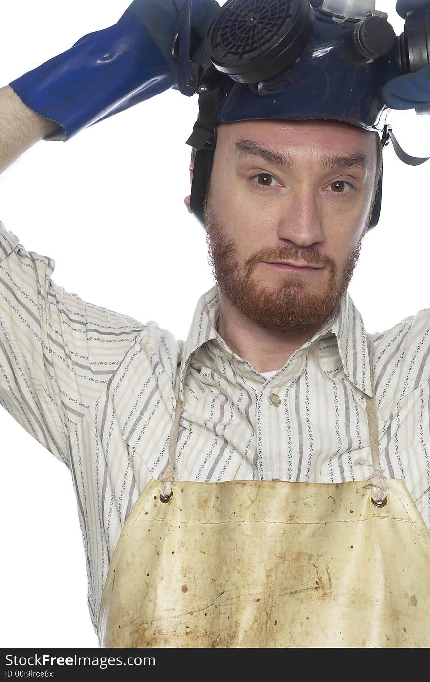 Bearded mand takes off hazardous materials safety mask.  Her is wearing blue rubber gloves and a biege chemistry stained apron. Bearded mand takes off hazardous materials safety mask.  Her is wearing blue rubber gloves and a biege chemistry stained apron.