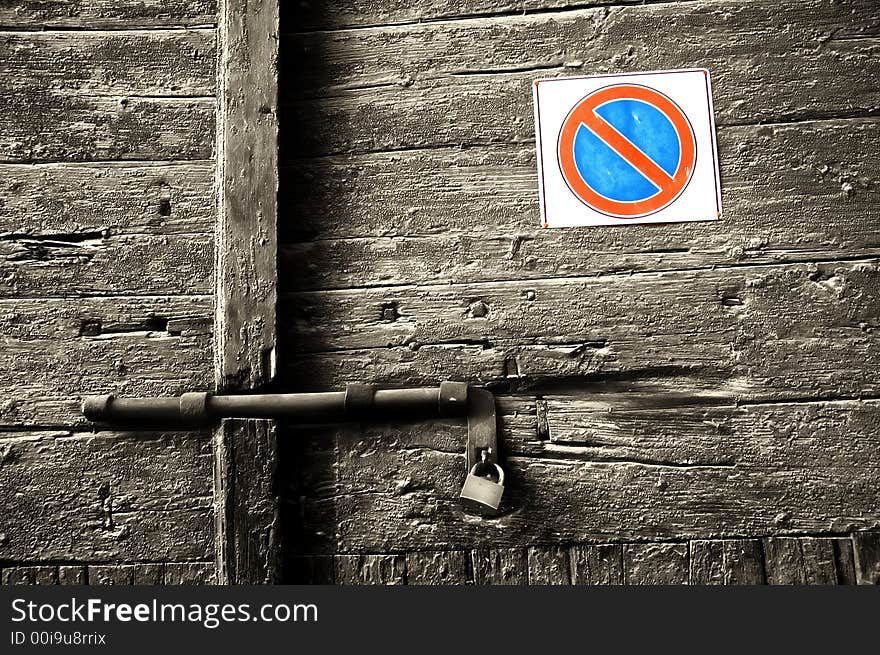 Forbidden sign on decayed wooden door with lock