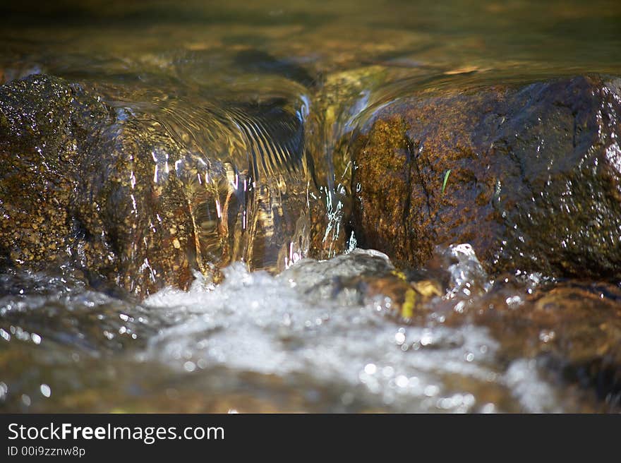 Little rill with brown stones and rocks