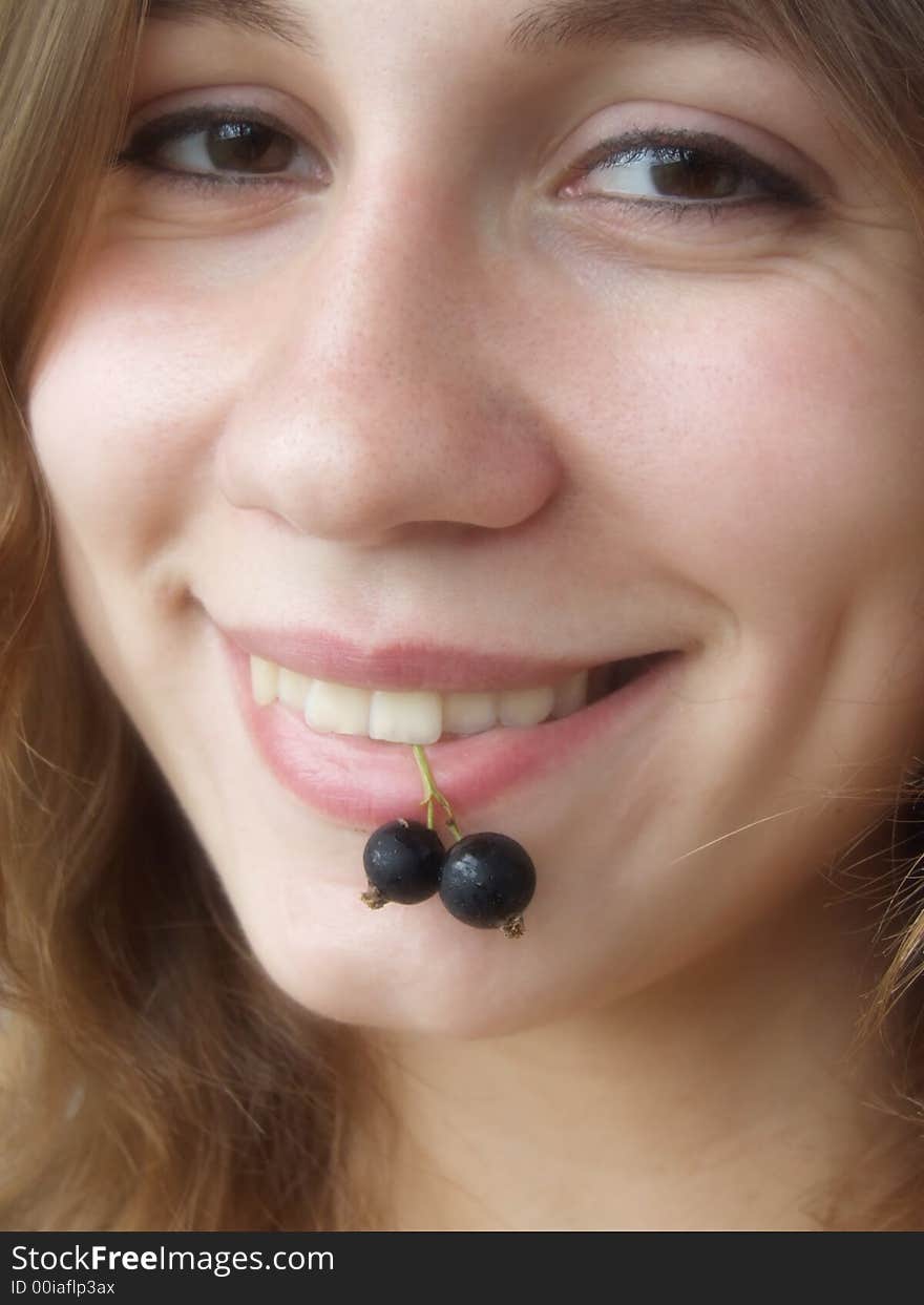 Smiling girl with berries in her teeth. Soft focus. Smiling girl with berries in her teeth. Soft focus