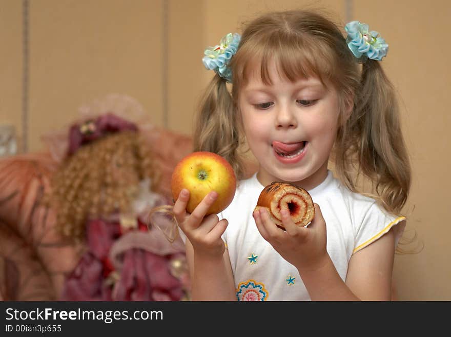 A girl holding an apple and a cake. A girl holding an apple and a cake