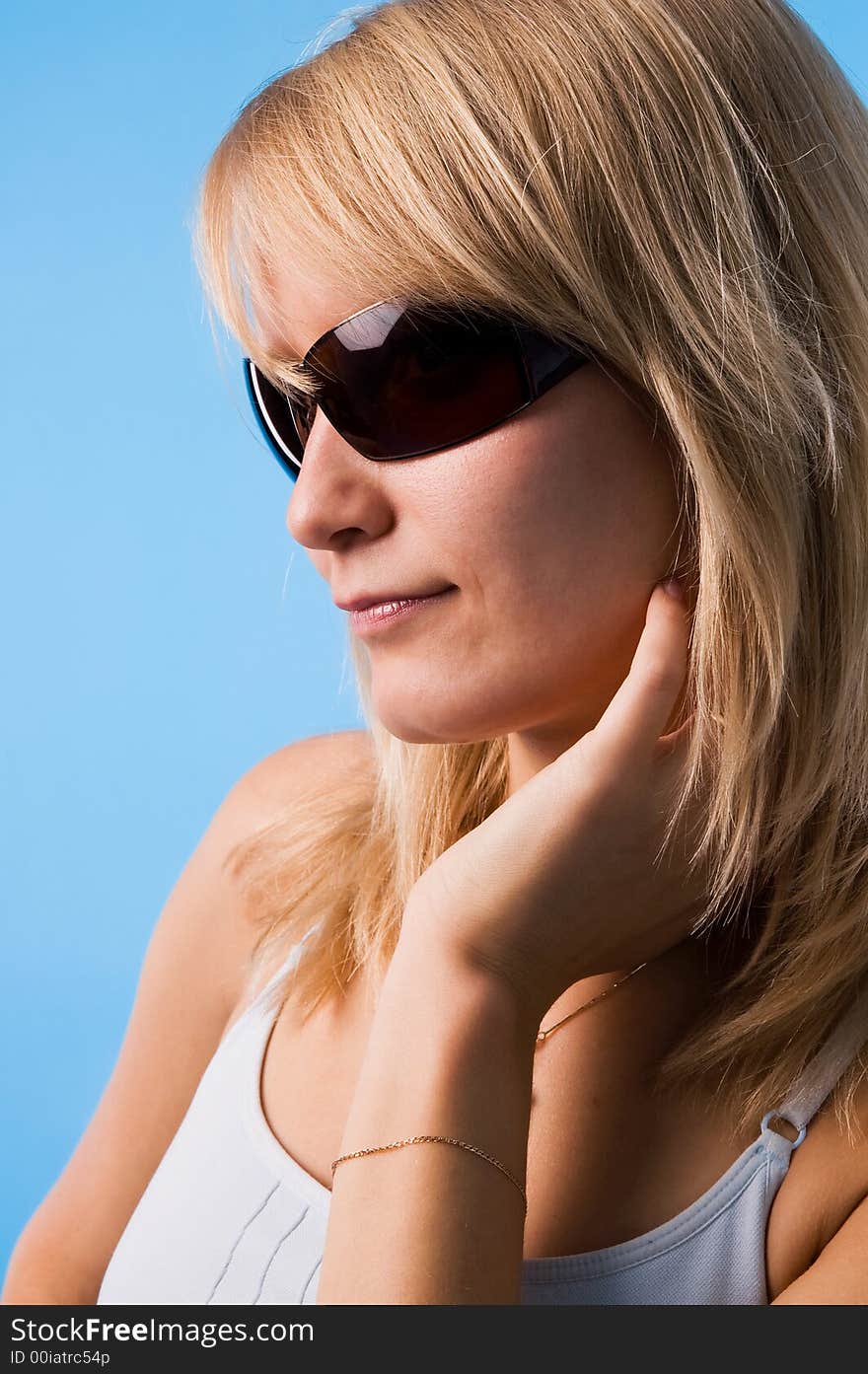 The girl in glasses on a blue background in studio