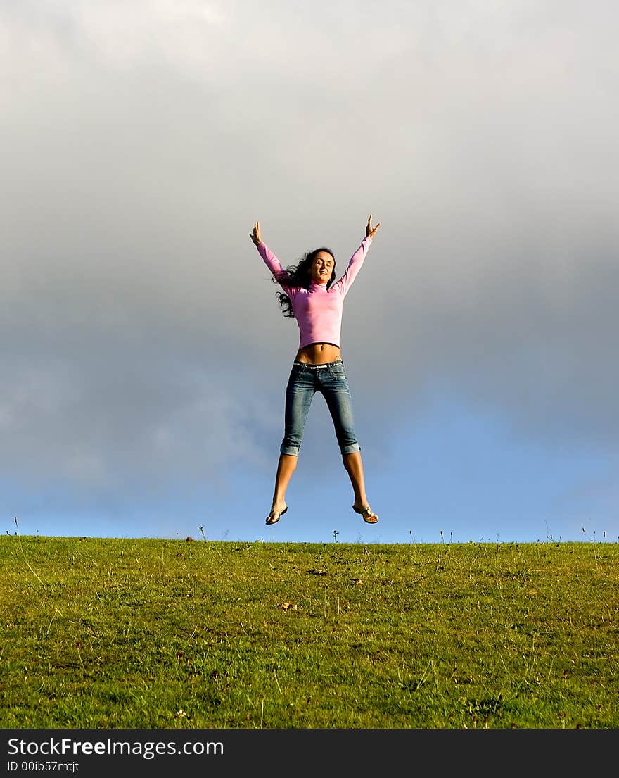 Happy young beautiful girl jumping in the green field. Happy young beautiful girl jumping in the green field.